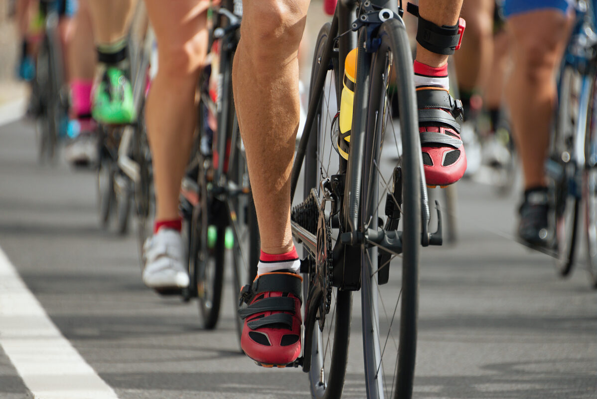 Nahaufnahme von Radschuhen und Beinen der Triathleten auf der Radstrecke