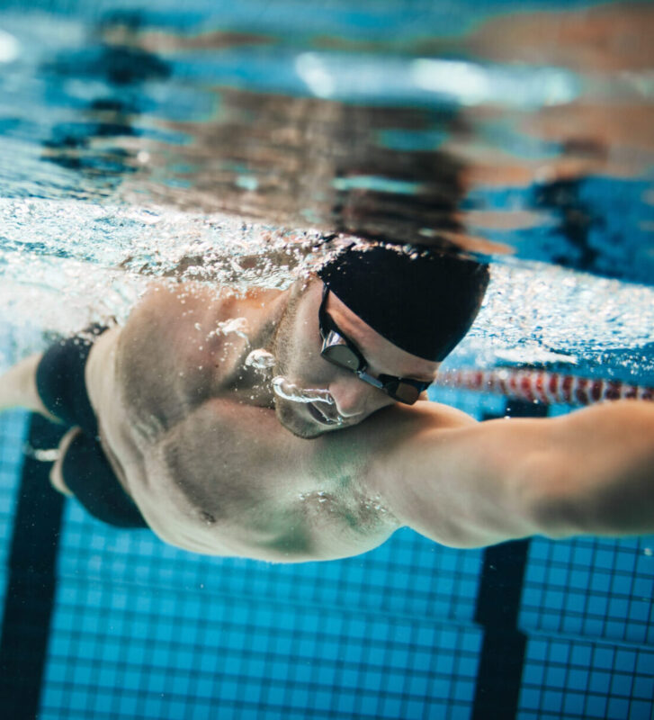 Schwimmer unter Wasser im Schwimmbecken, trainiert