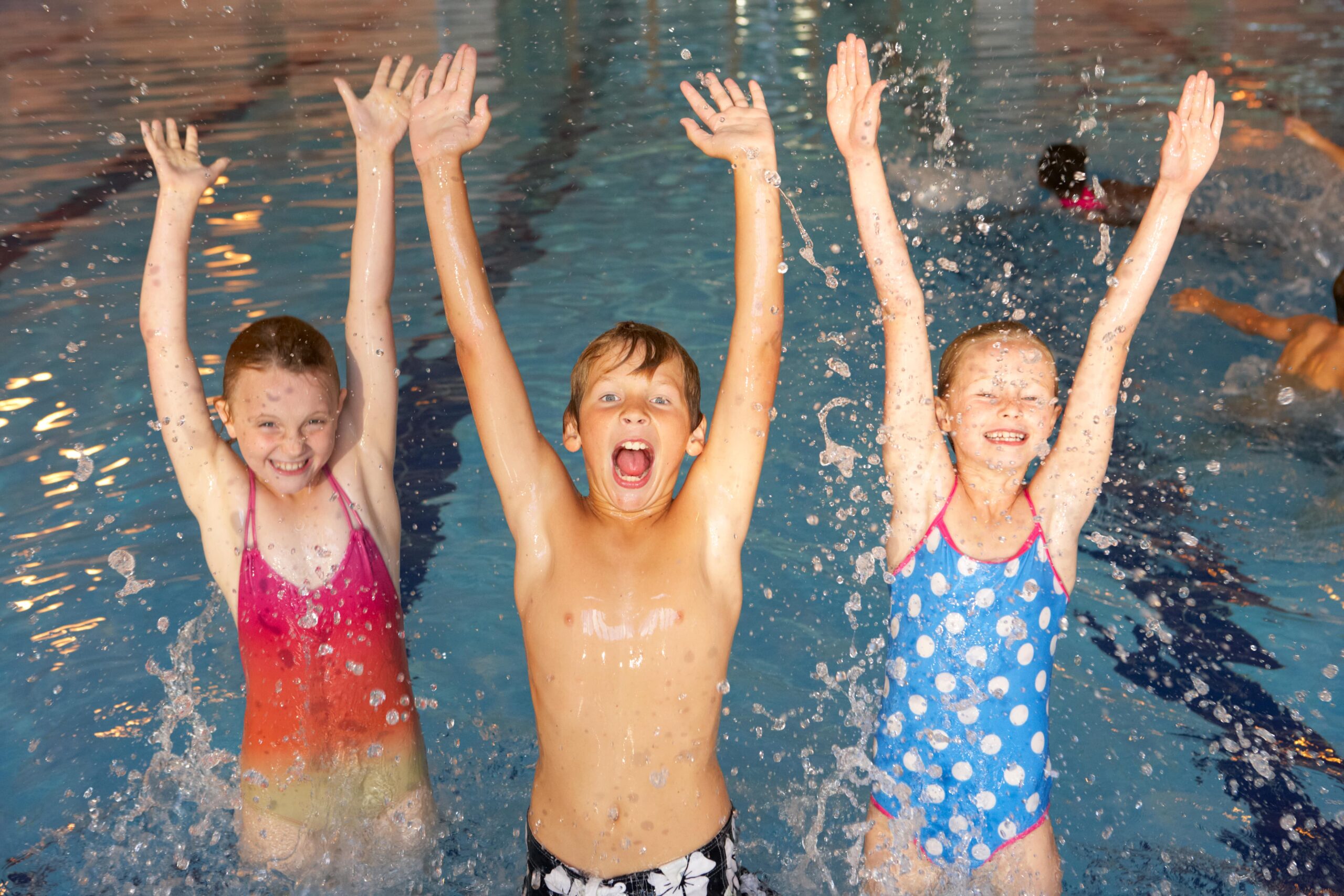 Kinder lassen sich in Pool fallen während Schwimmstunde